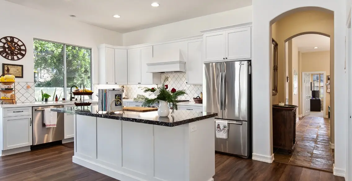 White painted shaker kitchen with quartz tops and full height arabesque tile backsplash