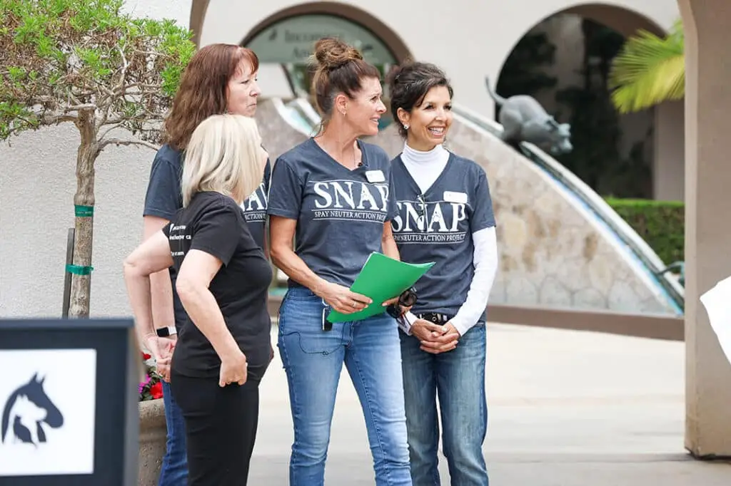 Nicole Donnelly & Dorell Sackett stand with two other members of the Spay Neuter Action Project at a non-profit event