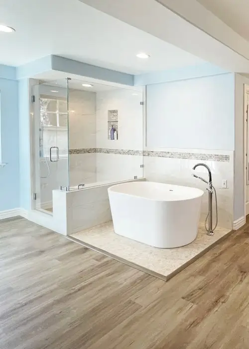 Master bath shower next to free standing tub. Luxury vinyl planks on floor.